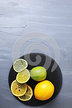 still life citrus fruits orange lemon lime lie on a tray on a gray background with room for text. Fruits benefit vitamins