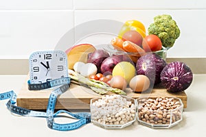 Still life with a clock, a tape measure and healthy food