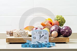 Still life with a clock, a tape measure and healthy food