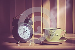 Still life of coffee cup and clack on table