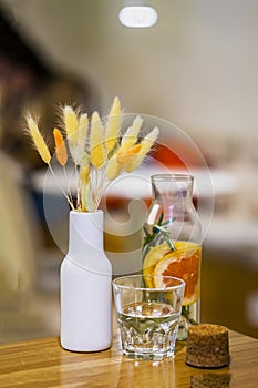 Still life. Cold Infused detox water with citrus, next to glass, bunch of dried flowers. Healthy lifestyle and diet