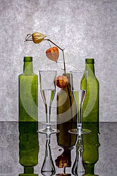 Still life with colored bottles on a reflective surface