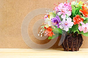 Still life with colourful flower bunch in wood vase on wooden table and copy space
