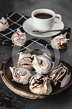 Still life composition, many white and chocolate meringues with coffee cup on grey cement background, food and homemade baking