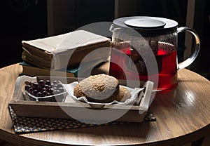 Still-life, covered wooden table, breakfast with tea, currants and nut cookies