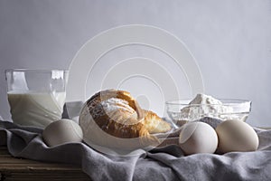 Still life of croissants, eggs, milk and flour.