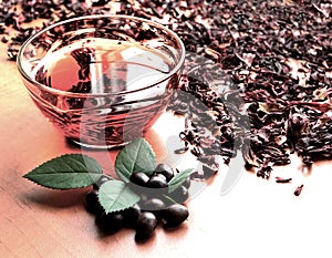 Still life cup of black tea with mint leaves on dried karkade tea background