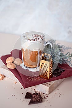 Still life with a cup of coffee latte wit wipped cream, cookies and cade branch