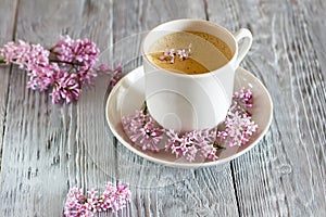 Still life with cup of coffee and spring lilac flower