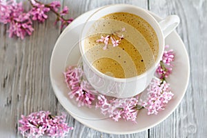 Still life with cup of coffee and spring lilac flower