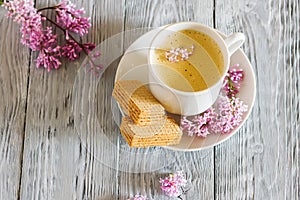 Still life with cup of coffee and spring liliac flower