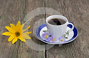 Still life a cup of coffee and a yellow flower on a table