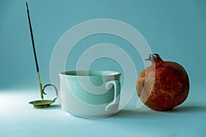Still life with cup of tea and natural pomegranate