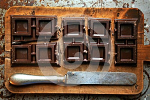 Still life with dark chocolate on a wooden board