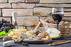 Still life with different varieties of cheese on wooden plate