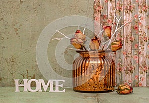 Still life with dry rose flowers in a vintage glass vase