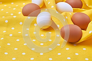 Still life eggs on a yellow wrinkled fabric cloth.