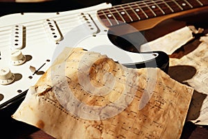 Still life with an electric guitar and old sheet music closeup