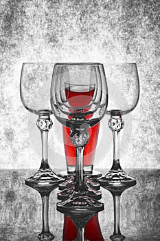 Still life with empty glass goblets and red bottle