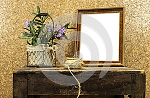 Still life: empty picture frame mockup on wooden old desk table. purple flowers vase and rope. Elegant working space, home office