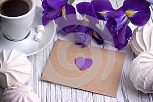 Still life with envelop heart sign iris flowers on white wooden background. Wedding.