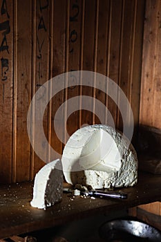 Still life with farmer cheese and a knife on rustic wooden background