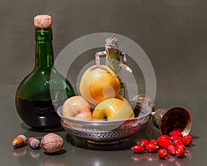 still life with a female Yemeni chameleon sitting on a green apples next to green bottle and melchior glass