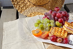 Still life and food photo. A plate of fruit stands on burlap on a wooden floor