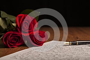 Still life of a fountain pen, paper and flowers roses