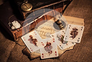 a still life of four playing cards on burlap and a beautiful still life with old books and a clock