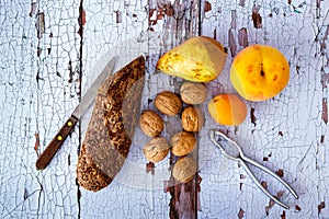 Still life with fresh bread with cereals, walnuts, pear, peach and apricot