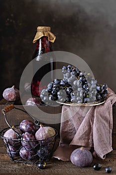Still life with fresh fruits, fruit juice. grapes, figs, plums