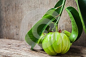 Still life with fresh garcinia cambogia on wooden background photo