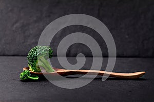 Still life with fresh green broccoli on black stone plate