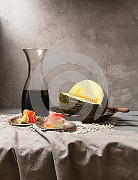 Still life with fresh melon, jamon and red wine on the table