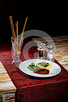 Tasty Omelet with Salmon, Salad, Bread Sticks, Salt and Pepper on the wooden table with red tablecloth. Dark theme, with copyspace