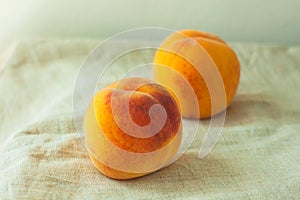 Still life with fresh peaches on linen cloth background on wooden table. Bright juicy summer fruits, flatlay