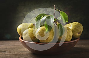 Still life with fresh pears with leaves in a bowl