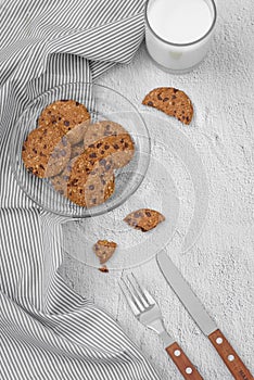 Still life of freshly baked chocolate chip cookies on plate on t