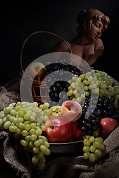 Still life with fruit and antique female bust in retro style