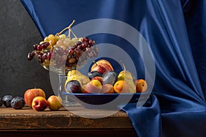 Still life with fruit and a bottle of wine. Apples, pears, plums, grapes and nectarines.