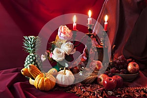 Still life of fruits and vegetable on the table and candle stand