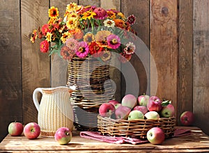 Still life with garden flowers and apples in the basket.