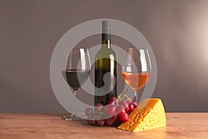Still life with glass and bottle of wine, cheese and grapes