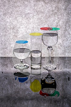 Still life with glass goblets on a reflective surface