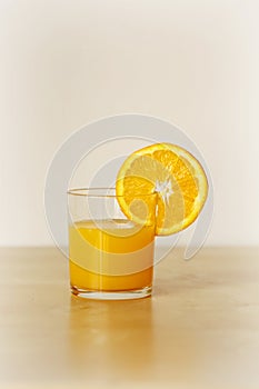 Still life of glass of orange juice with orange slice