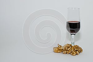 Still life with a glass of red wine and a handful of walnuts