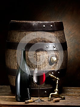 Still-life with glass of wine, bottle and barrel.