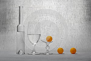 Still life with glassware and a broken glass and orange balls
