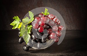 Still life with grape in the antique copper tin cup